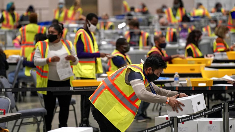 Election workers extract mail-in ballots in a secure room at the Pennsylvania Convention Center in Philadelphia, Pennsylvania, on November 3, 2020.